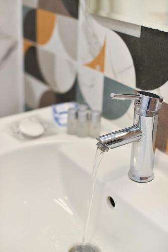 a bathroom sink with water running from a faucet at Hotel Palladium Sithonia in Kalamitsi