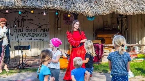a woman standing in front of a group of children at Przystań Tło dla Mew in Rydzewo