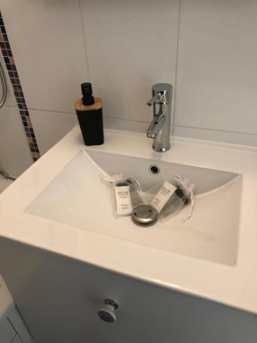 La salle de bains est pourvue d'un lavabo blanc et d'un robinet. dans l'établissement Le Studio 102, à Villers-sur-Mer