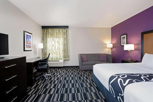 a hotel room with a bed and a desk and a chair at La Quinta by Wyndham Cedar City in Cedar City