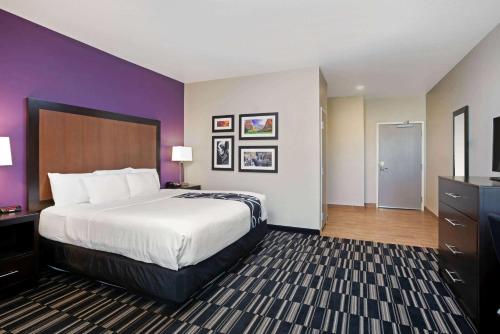 a hotel room with a large bed and purple walls at La Quinta by Wyndham Cedar City in Cedar City