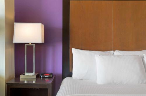 a bed with a lamp on a nightstand next to a bed with white sheets at La Quinta by Wyndham Cedar City in Cedar City