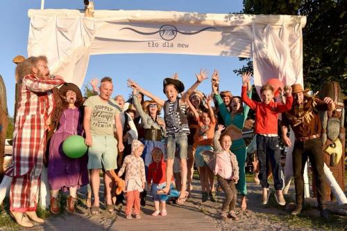 a group of people jumping up in the air at Przystań Tło dla Mew in Rydzewo