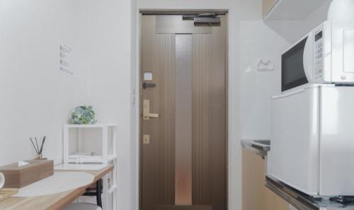 a kitchen with a brown door and a desk at Sun Hotel in Tokyo