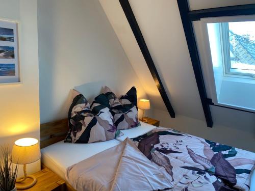 a bedroom with a bed with pillows and a window at Strandnah in Wenningstedt in Wenningstedt
