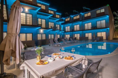 a hotel with a table with food next to a swimming pool at Hotel Palladium Sithonia in Kalamitsi