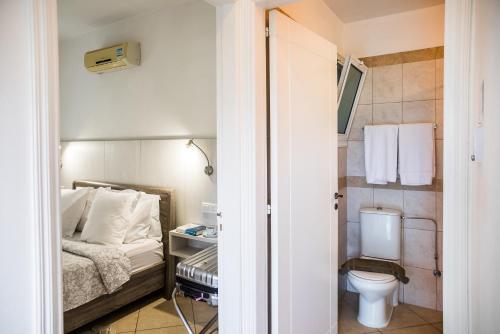 a small bathroom with a bed and a toilet at Artemis Cynthia Complex in Paphos