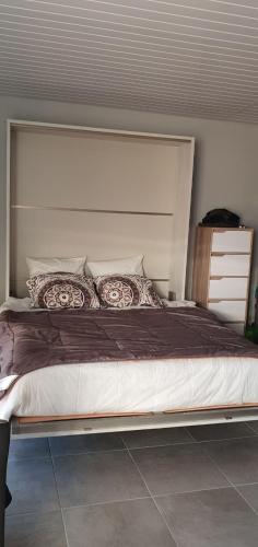 une chambre avec un grand lit avec une grande tête de lit dans l'établissement Studio à 50m des plages 