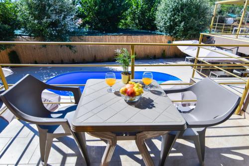 a table with a bowl of fruit and two glasses of wine at Hotel Palladium Sithonia in Kalamitsi