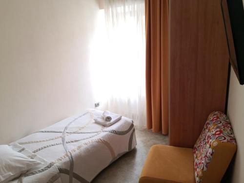 a bedroom with a bed and a window at Gostilna pri Dragici, gostilna s prenočišči, d.o.o. in Sežana