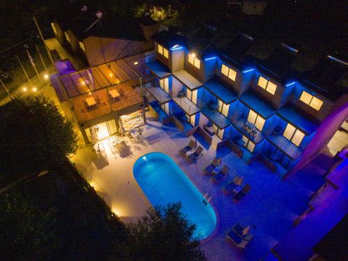a large building with a blue swimming pool at night at Hotel Palladium Sithonia in Kalamitsi