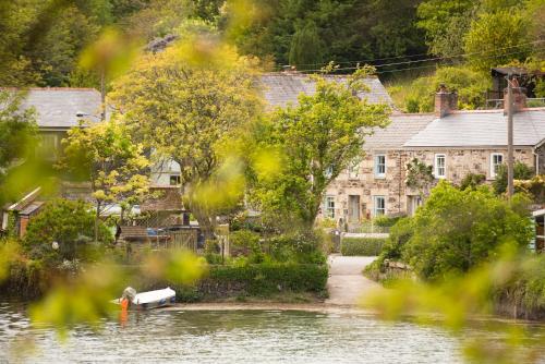 a house on the river with a boat in the water at Navas Nook in Falmouth