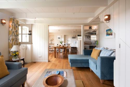 a living room with two blue couches and a table at Navas Nook in Falmouth