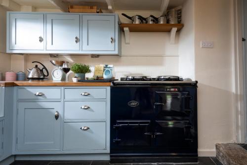 a kitchen with a black stove and white cabinets at Navas Nook in Falmouth