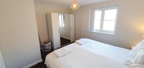 a bedroom with two white beds and a window at Garland Modern Apartment Tilbury with Parking in Tilbury