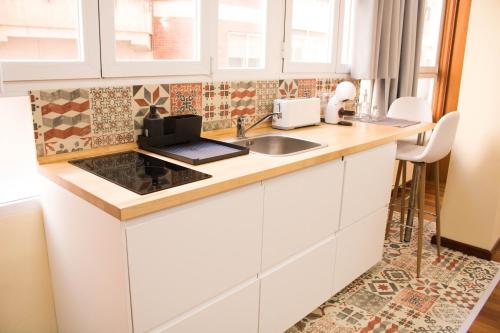 a kitchen with white cabinets and a sink at LOFT CENTRO ALMERIA in Almería