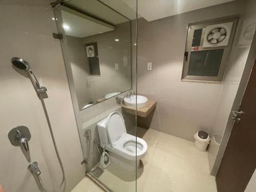 a bathroom with a toilet and a glass shower at Atrium - ICONIC APARTMENT in Sri Jayewardenepura Kotte