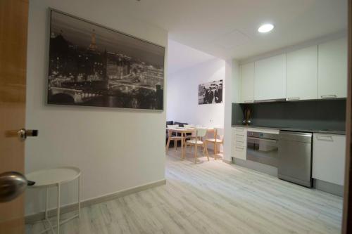 バルセロナにあるロヘル デ ユリア デザイン アパートメントのキッチン(白いキャビネット、テーブル付)、ダイニングルーム