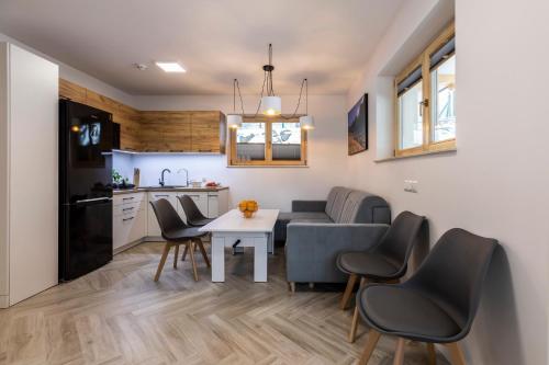 a kitchen and dining room with a table and chairs at TatryTop Apartamenty Alpejski SPA in Kościelisko
