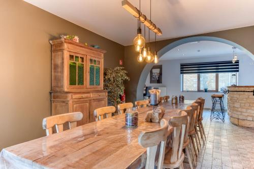 a large dining room with a large wooden table and chairs at Gîte de la cascade in Villers-devant-Orval