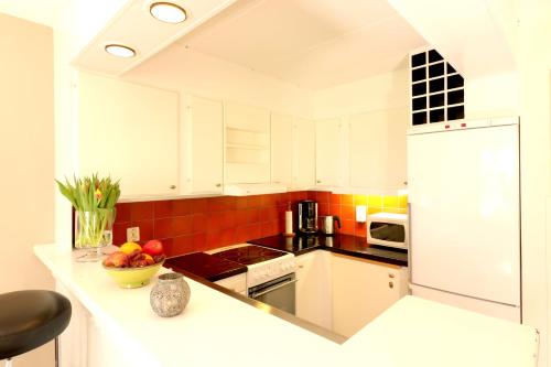 a kitchen with white cabinets and a white refrigerator at Smygehus Havsbad in Smygehamn