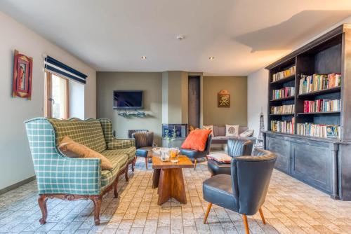 a living room with chairs and a table and bookshelves at Gîte de la cascade in Villers-devant-Orval