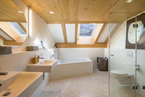 a bathroom with a tub and a sink and a toilet at Maisonettewohnung am Wössener See in Unterwössen