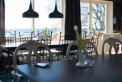 a dining room with tables and chairs and a window at Smygehus Havsbad in Smygehamn