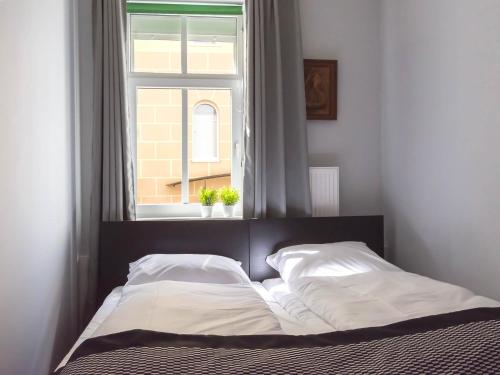a bed in a bedroom with a window at VacationClub - Willa Carmen Apartment 3 in Świnoujście