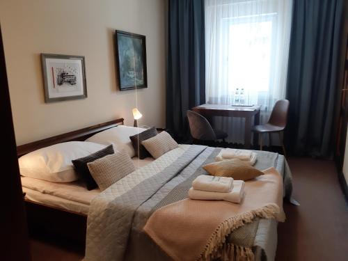 a bedroom with a large bed with towels on it at Resort Kasprowy Wierch in Zakopane
