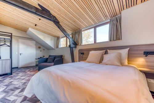 ein Schlafzimmer mit einem großen Bett in einem Zimmer in der Unterkunft Les chambres du Domaine du Vieux Château in Abtei Orval