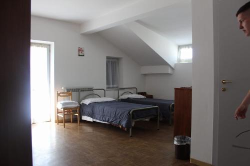 a bedroom with two beds in a room with a ceiling at Casa per ferie BeatoRosaz in Cesana Torinese