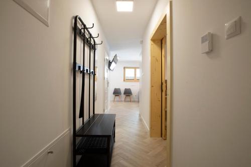 a hallway with a black bench and two chairs at TatryTop Apartamenty Alpejski SPA in Kościelisko