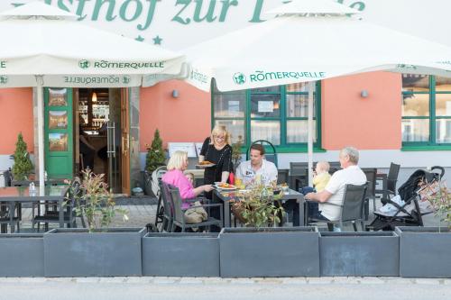 a group of people sitting at tables outside a restaurant at Gasthof zur Linde in St. Andrä am Zicksee