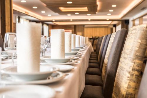 a long table in a restaurant with white plates and napkins at Gasthof zur Linde in St. Andrä am Zicksee