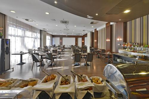 a restaurant with tables and chairs and a buffet at Hotel City Inn in Budapest