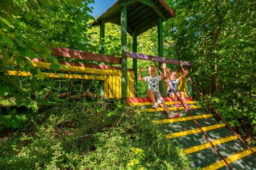 two children are sitting on a play structure at Hotel Schloßberg in Gräfenberg