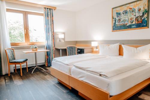 a hotel room with a large bed and a desk at Hotel Schloßberg in Gräfenberg