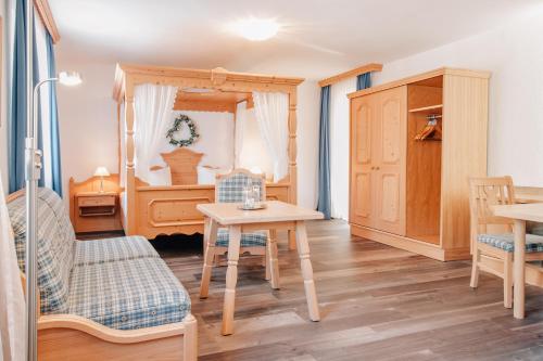 ein Schlafzimmer mit einem Tisch, Stühlen und einem Bett in der Unterkunft Hotel Schloßberg in Gräfenberg
