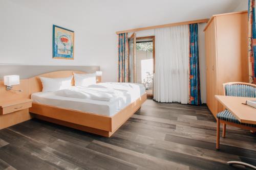 a bedroom with a bed and a desk and a table at Hotel Schloßberg in Gräfenberg