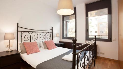 a bedroom with a black bed and two windows at RAMBLA BEACH Barcelonastuff Apartments in Barcelona