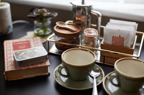 a table with two cups of coffee and a cell phone at The Quarrymans Arms in Corsham