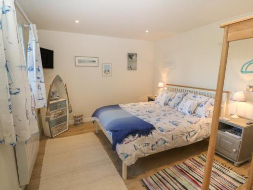 a bedroom with a bed with a blue comforter at The Sail Loft in Pwllheli