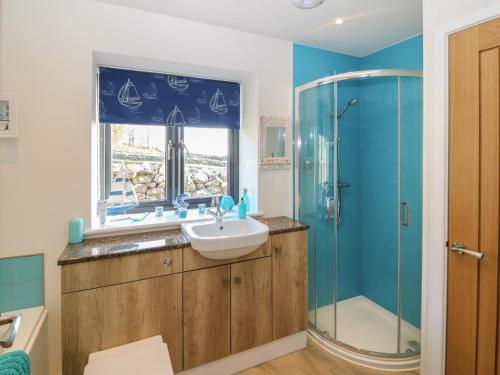a bathroom with a sink and a shower at The Sail Loft in Pwllheli