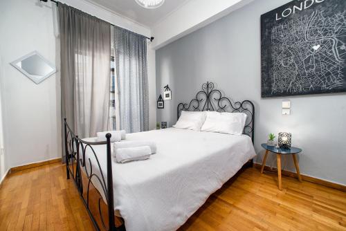 a bedroom with a large white bed and a table at Acropolis Area Flat in Athens