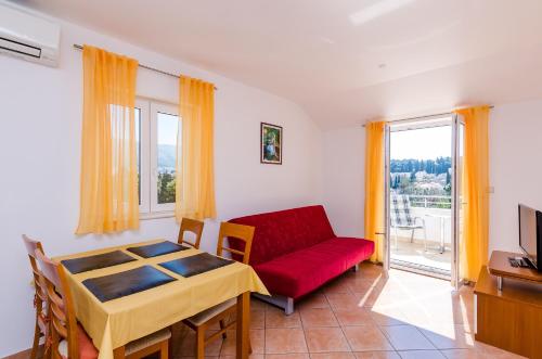 a living room with a red couch and a window at Apartments Villa Perla in Dubrovnik
