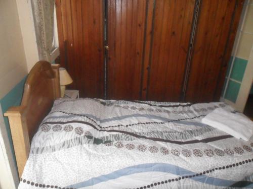 a bedroom with a bed with a wooden cabinet at Coconut Paradise Lodge in San Andrés