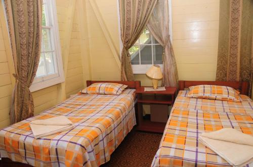 um quarto com duas camas e uma mesa e uma janela em Coconut Paradise Lodge em San Andrés