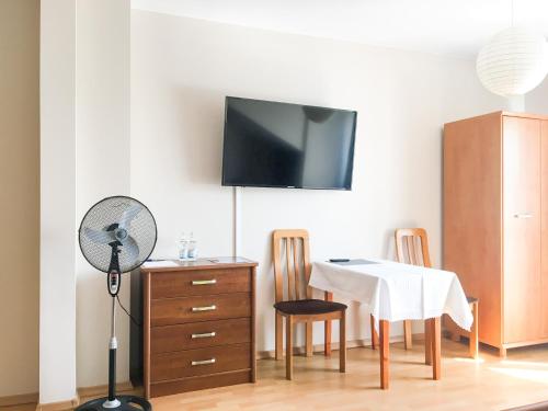 a room with a table and a fan and a table and chairs at Willa Zdrój in Ciechocinek