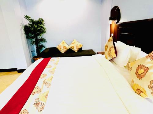 a bedroom with a bed with gold and white sheets and pillows at Green Mountain Hotel in Arusha